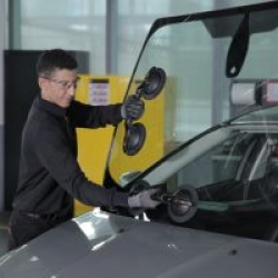 Technicien Carglass manipulant un pare-brise